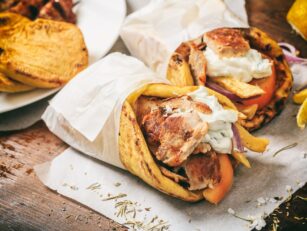 Greek gyros wraped in a pita bread on a wooden background. From Greek Food Truck Hires